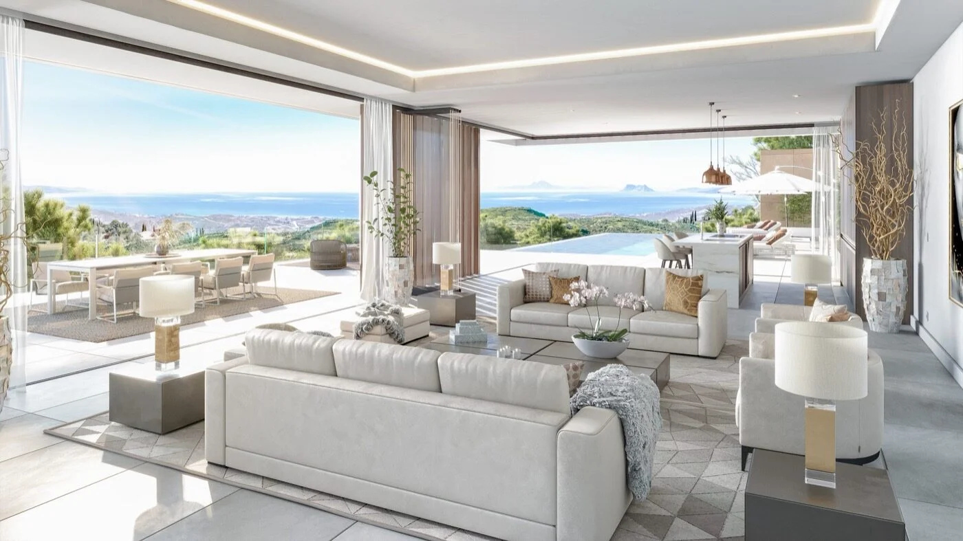 An open-plan villa living room with cream sofas opening onto a sea-view terrace